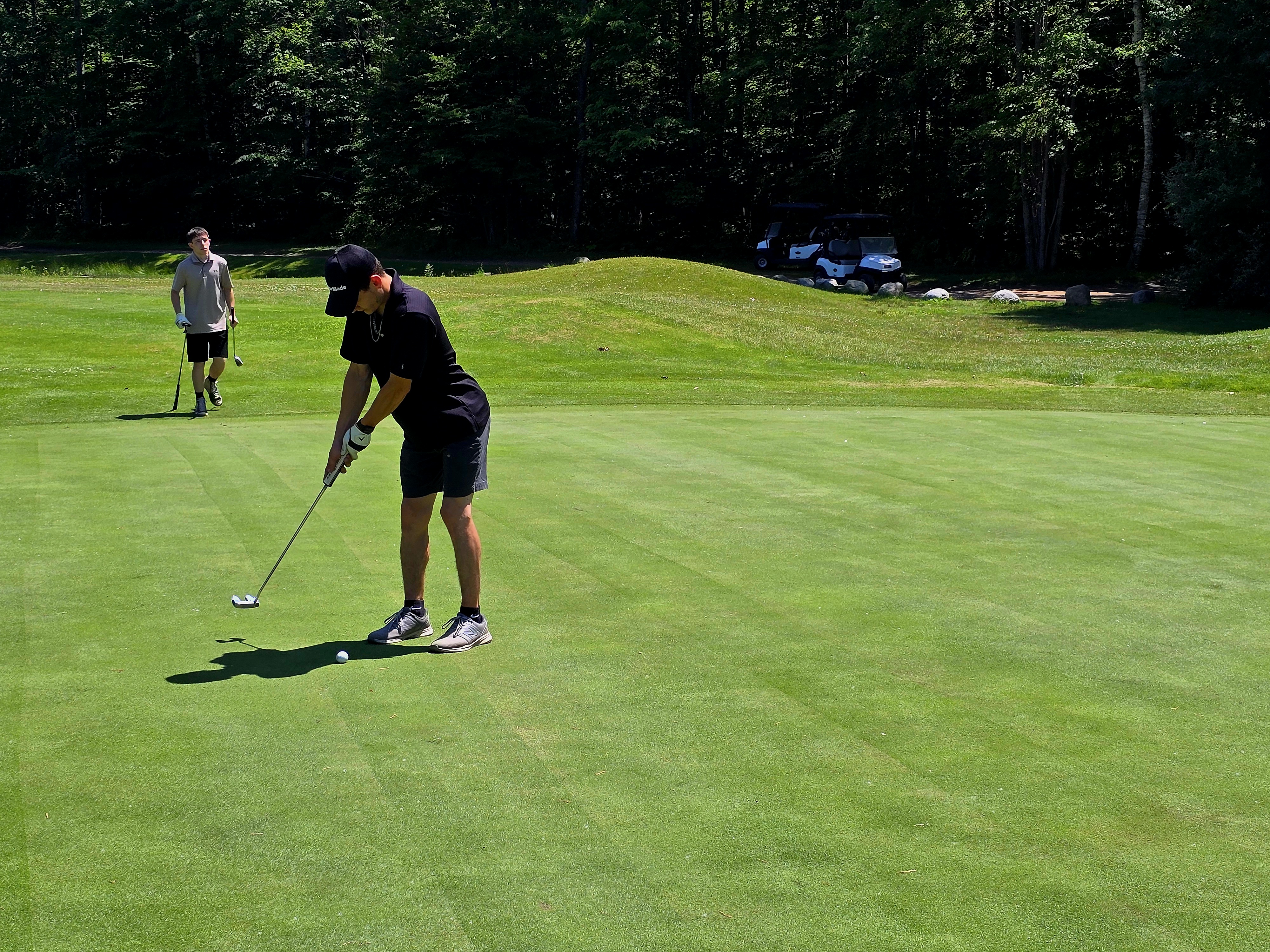 Golfer on golf course with other golfer in distance